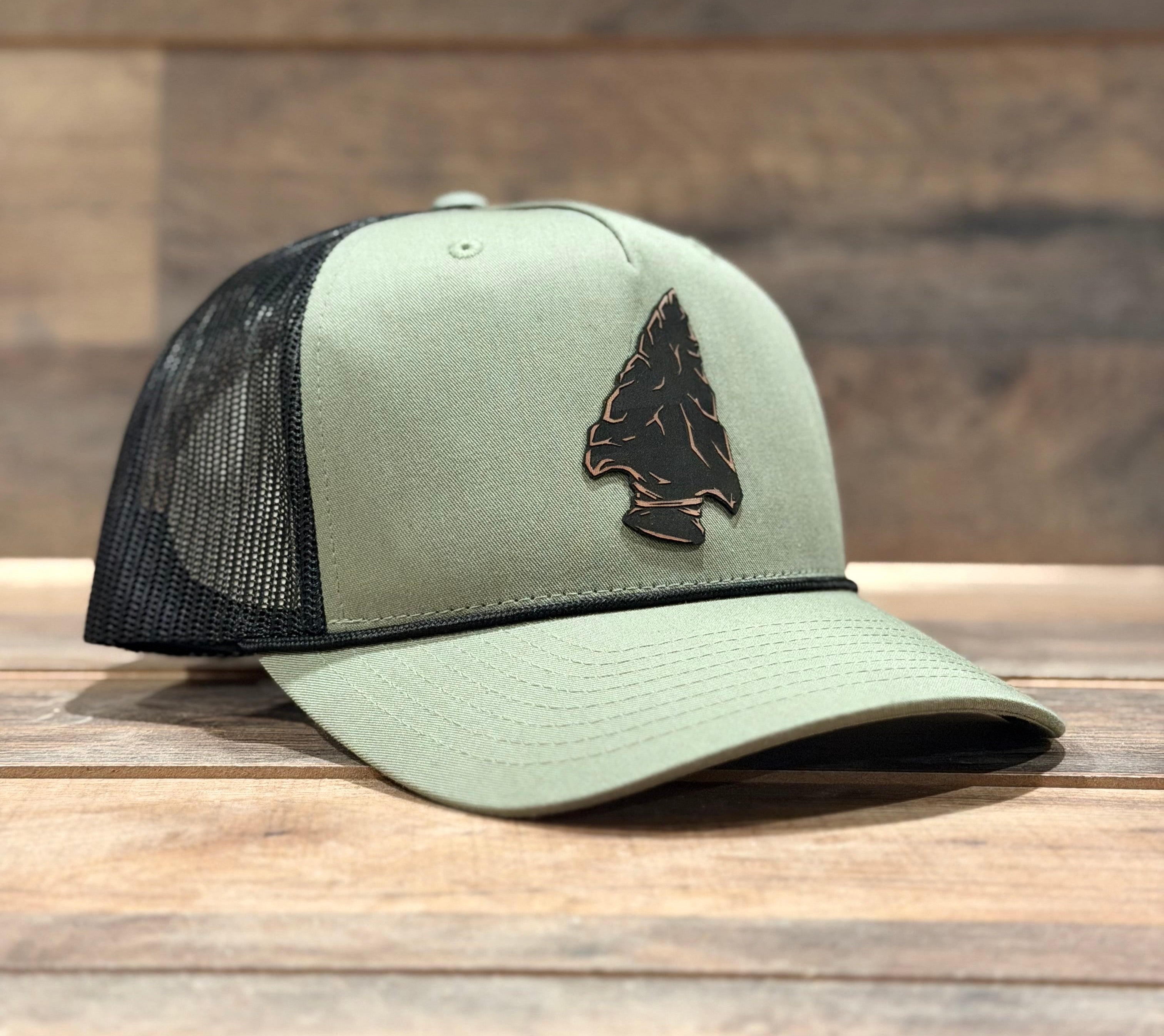 Green and black cap with a bear logo on a wooden surface and wooden wall background