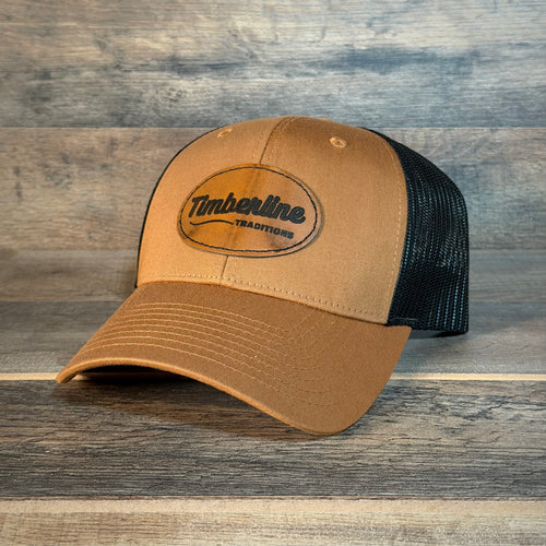 Brown trucker cap with black mesh back on a wooden surface