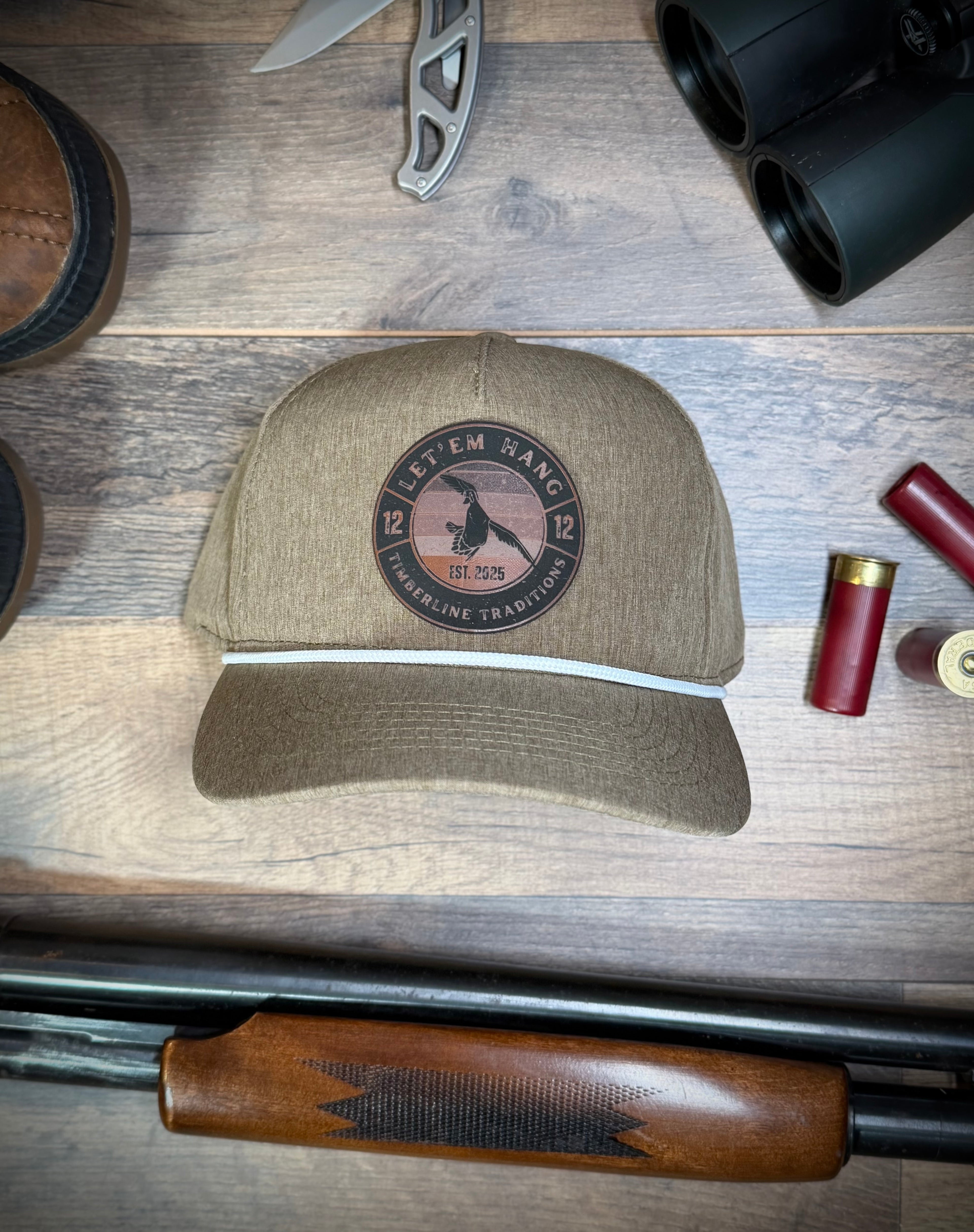 Marsh cap with duck hunting saying on it surrounding by duck hunting equipment