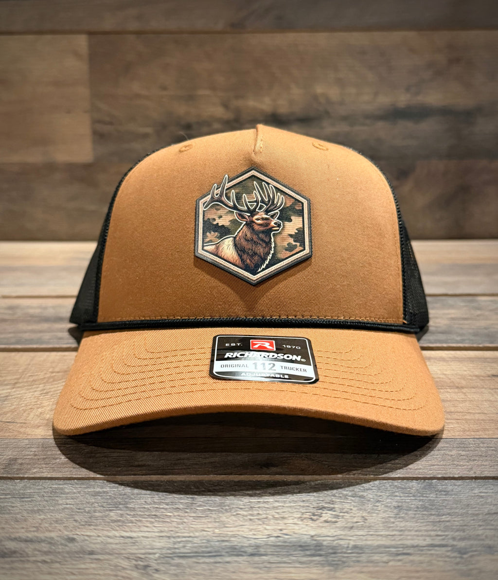 Brown trucker cap with a deer patch on a wooden surface