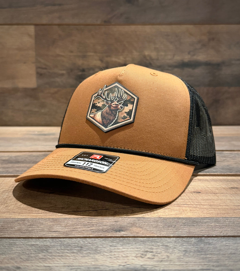 Brown trucker cap with a deer patch on a wooden surface