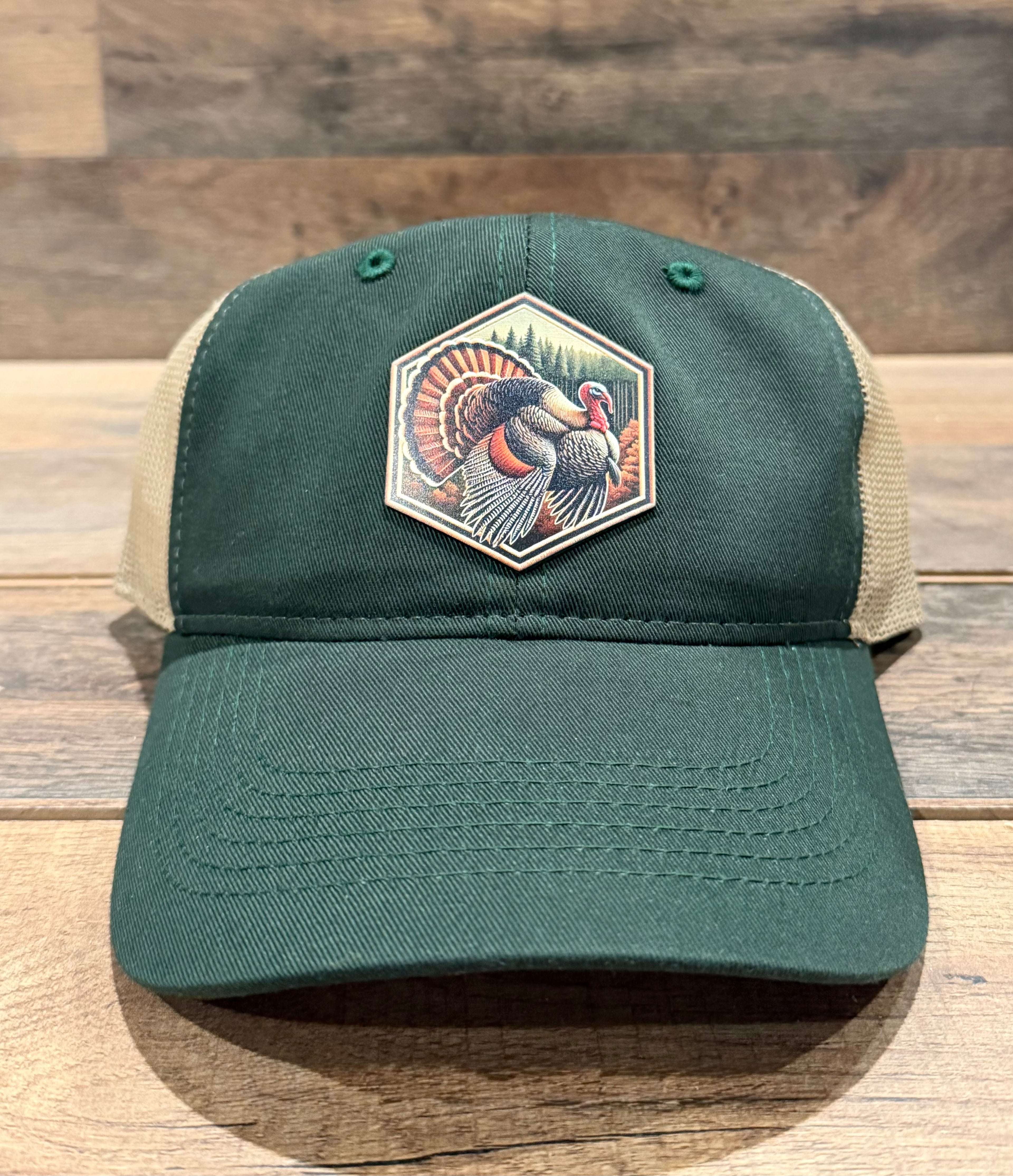 Green and beige cap with a turkey patch on a wooden surface