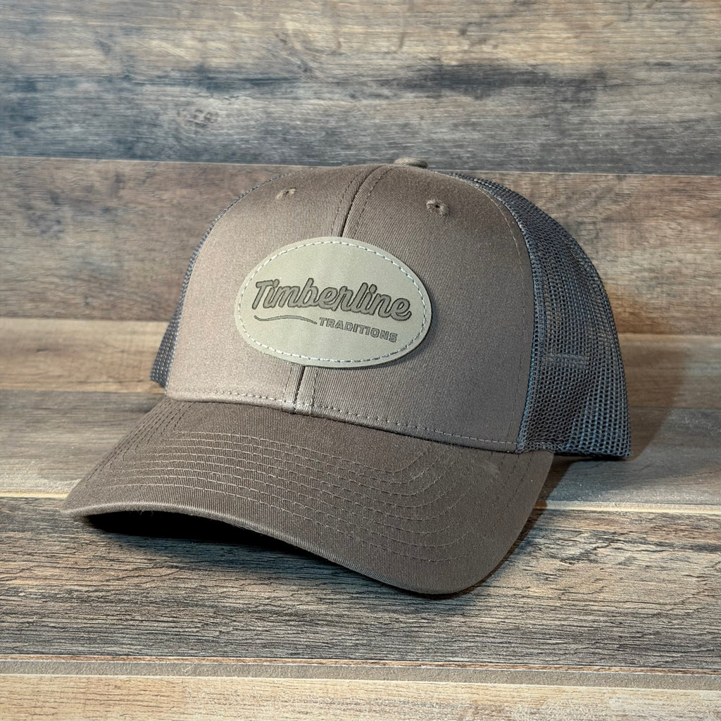 Gray cap with a leather patch on a wooden surface