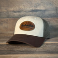 Beige and brown cap with leather patch on a wooden background