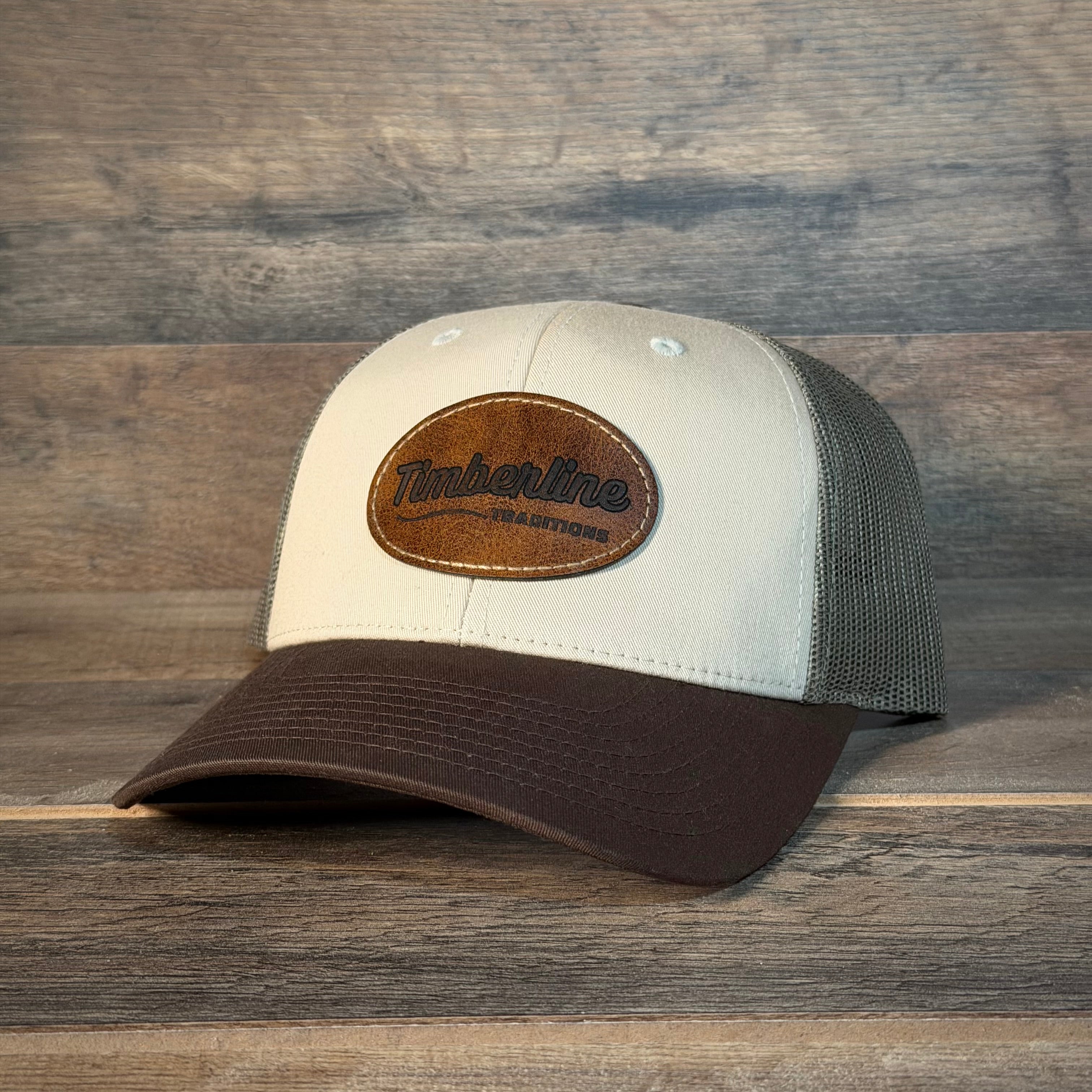 Beige and brown cap with leather patch on a wooden background