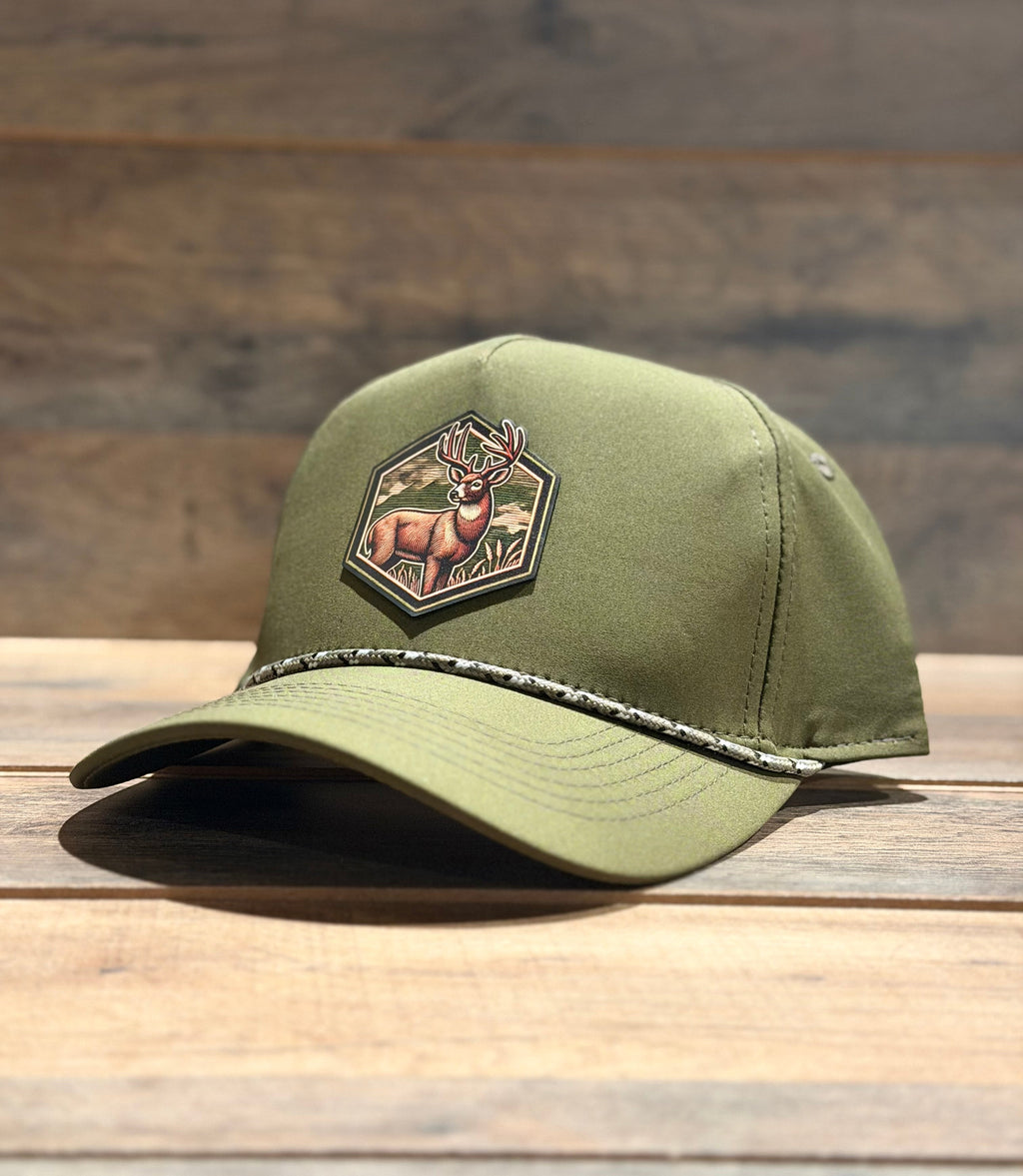 Green cap with a deer patch on a wooden surface